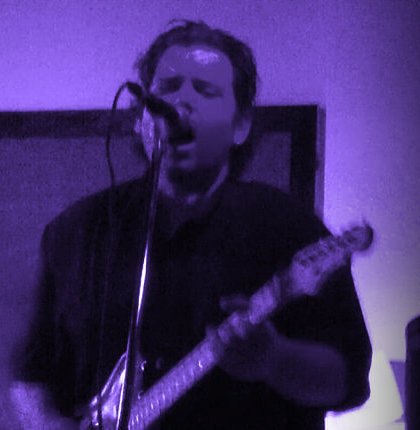 Jack with guitar under purple lights