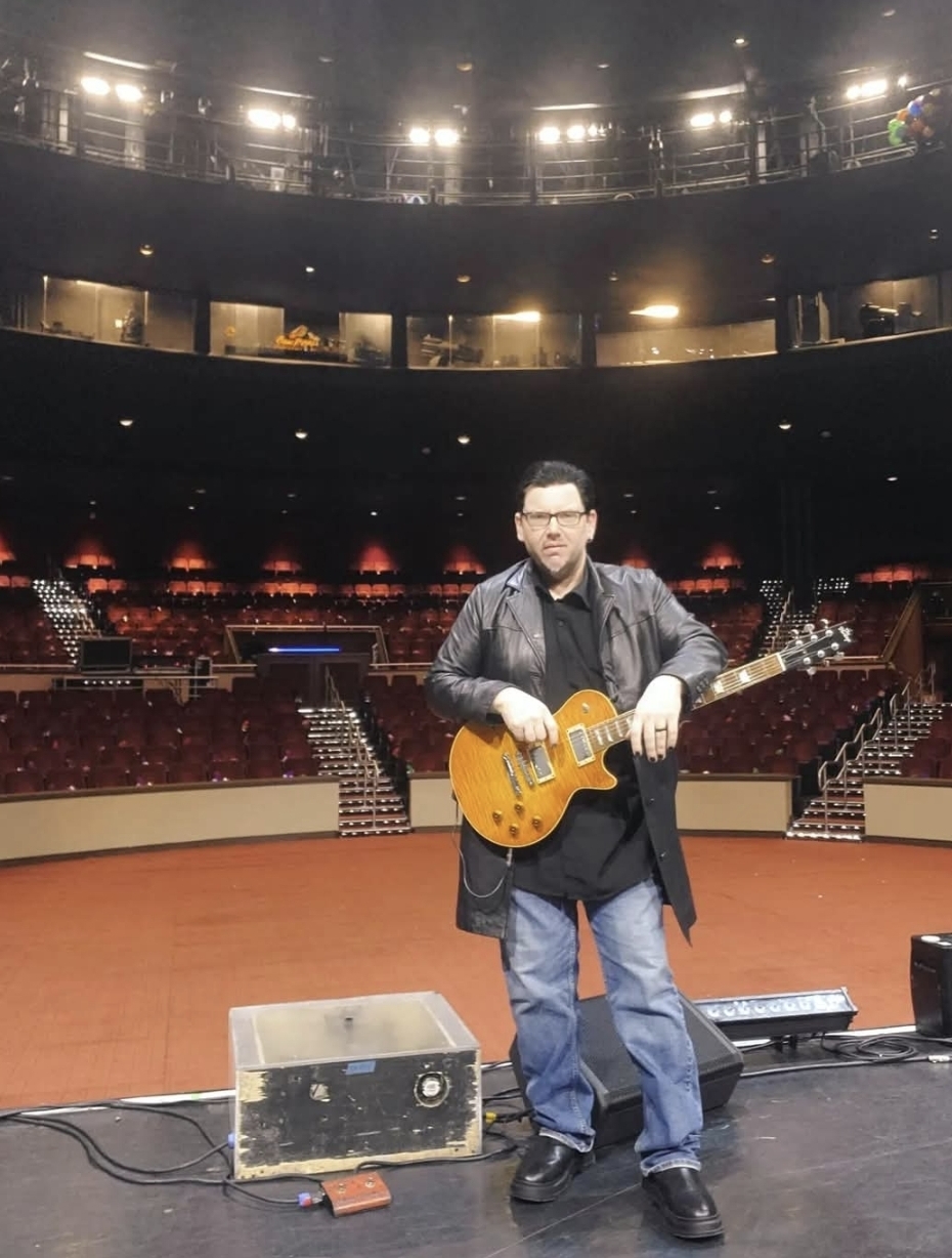 Jack Miele playing a Les Paul on an empty arena stage