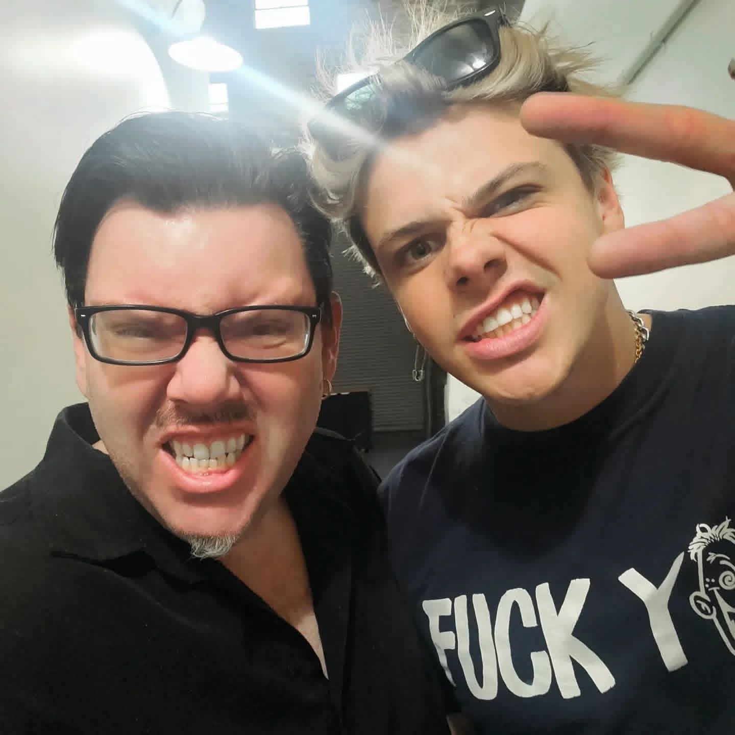 Jack Miele in a playful backstage selfie with a blonde friend flashing a peace sign